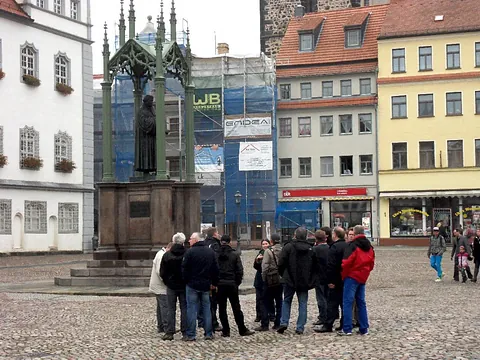 Menschen versammelten sich um ein Denkmal auf einem historischen deutschen Stadtplatz.