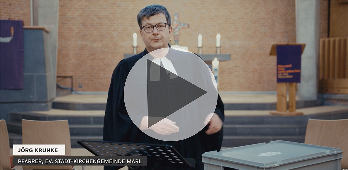 Pfarrer Jörg Krunke, im Talar mit Brille, predigt in Kirche.