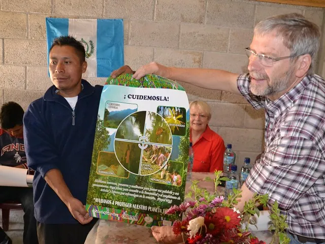 Zwei Männer präsentieren farbiges Plakat zum Umweltschutz.