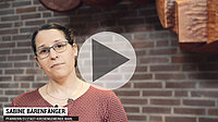 Sabine Baringer, Frau mit Brille, vor Backsteinwand, Video-Vorschau.
