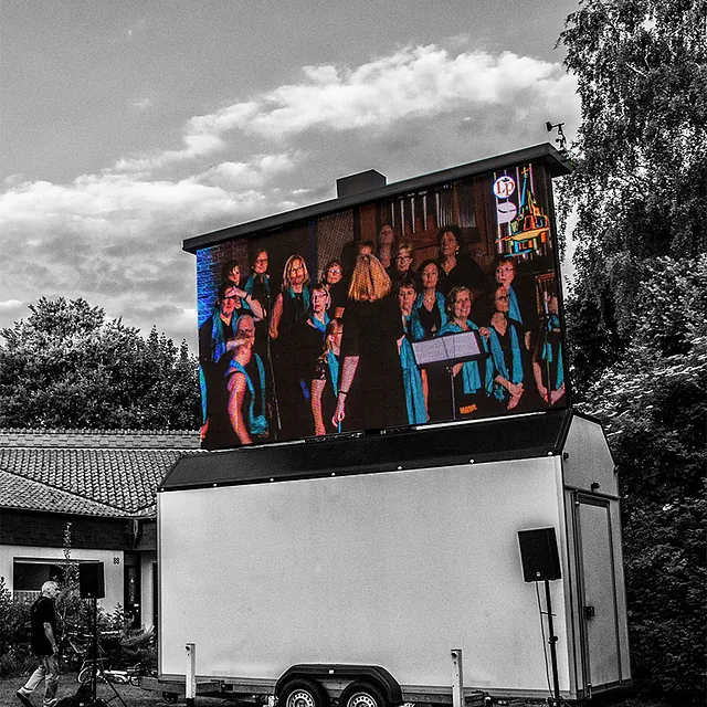 Große Außenleinwand zeigt eine Choraufführung.