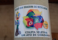 Recycling-Plakat mit Zeichentrickfigur, Kisten und Text.