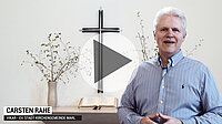 Carsten Rahe spricht in Kirche, Kreuz und Altar hinter ihm.