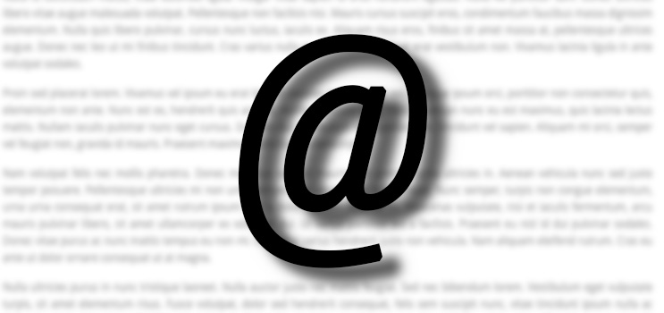 Großes schwarzes @-Symbol über unscharfem Text-Hintergrund.