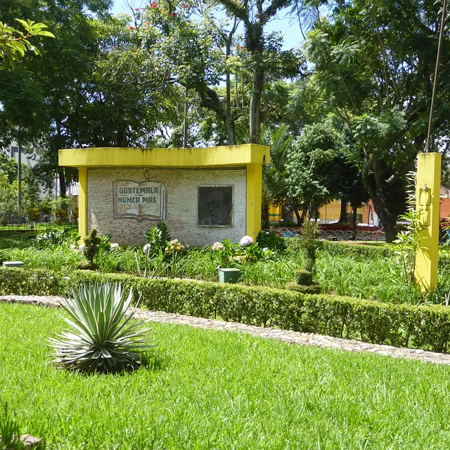  Ein leuchtend grüner Park mit einem gelben Gebäude und gepflegten Hecken.