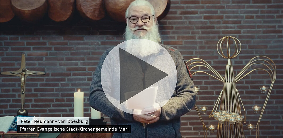 Peter Neumann-van Doesburg, Pfarrer, steht in Kirche mit Kreuz.