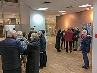 Gruppe leger gekleideter Leute unterhält sich in hellem Raum.