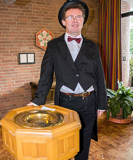 Lächelnder Mann mit Zylinder, Smoking und roter Fliege.