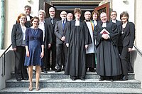 Gruppe von Geistlichen und Personen posiert auf Kirchenstufen.