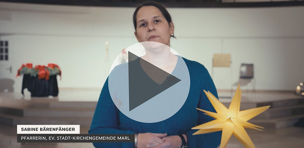 Pfarrerin Sabine Bärenfänger steht in Kirche mit großem Stern.