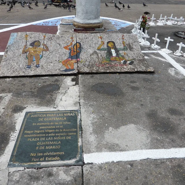 Guatemaltekisches Denkmal ehrt Mädchen, mit Malereien, Kreuzen, Plakette.