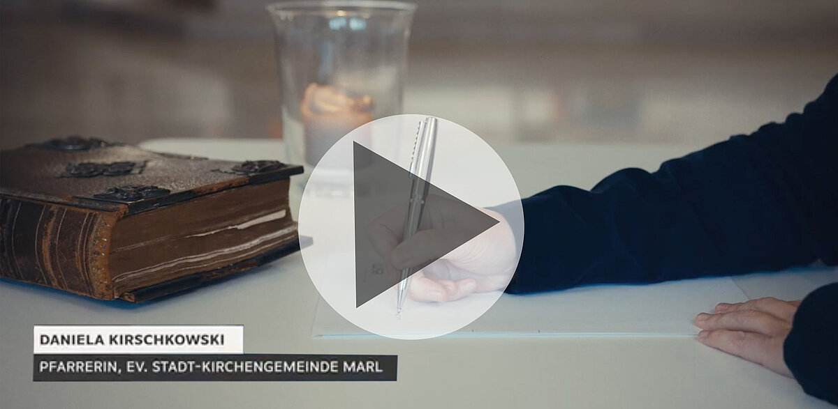 Daniela Kirschkowski, Pfarrerin, schreibt neben einer alten Bibel.