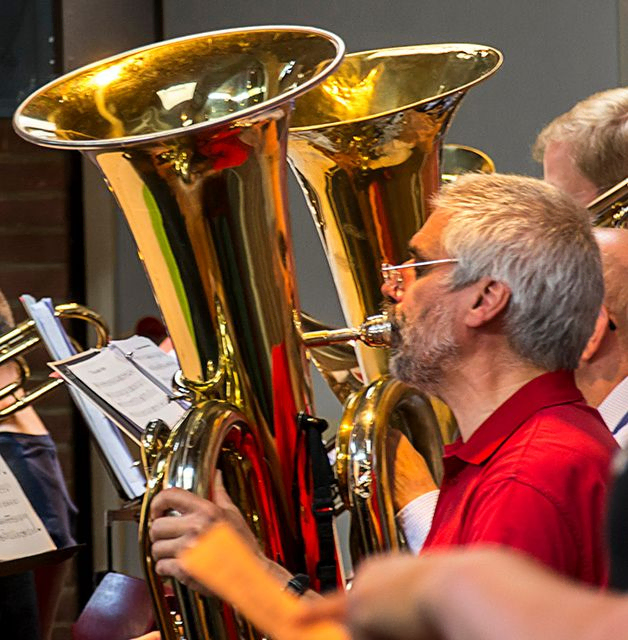Bärtiger Mann spielt goldene Tuba im Konzert, Nahaufnahme.