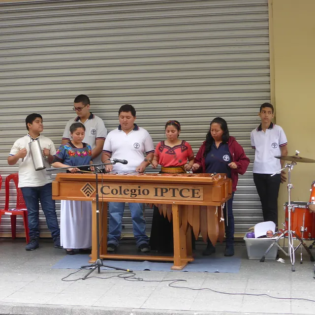 Schüler und Erwachsene musizieren draußen auf Marimba bei Colegio IPTCE.
