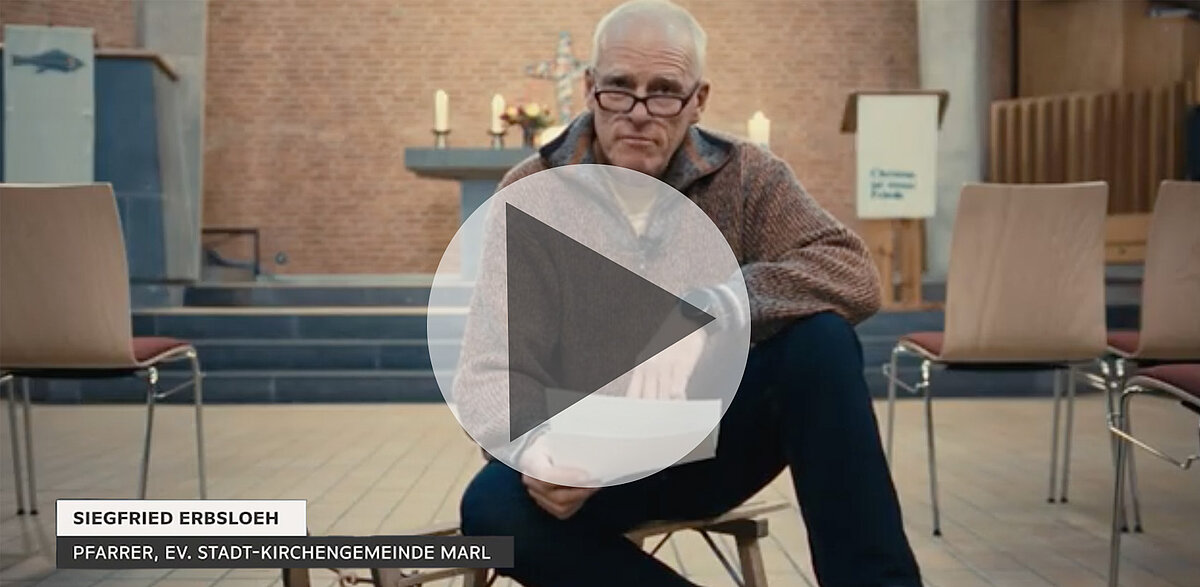 Siegfried Erbsloeh, Pfarrer, sitzt in Kirche, bereit zu sprechen.