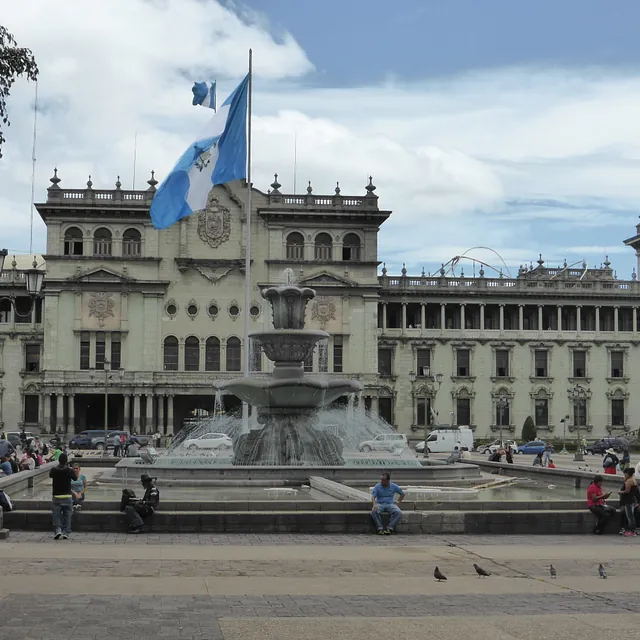 Nationalpalast und Brunnen von Guatemala-Stadt unter bewölktem Himmel.