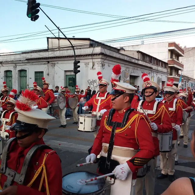 Musikkapelle in roten Uniformen spielt Trommel auf der Straße.