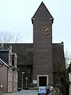 Eine traditionelle Backsteinkirche mit einem markanten Uhrturm.