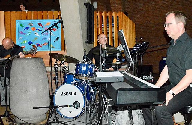 Band tritt auf: Bassist, Schlagzeuger, Keyboarder auf Innenbühne.
