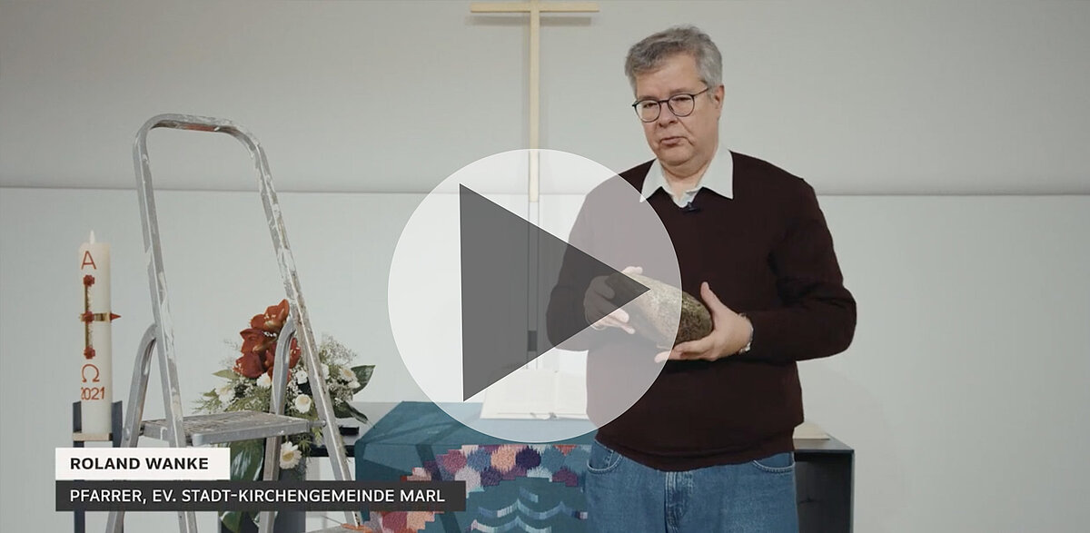 Pfarrer Roland Wanke hält Stein, lehrt in einer Kirche.