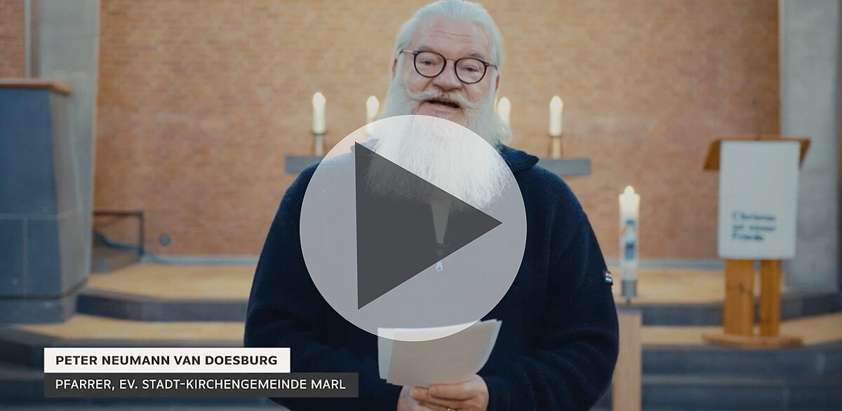 Pfarrer Peter Neumann van Doesburg in Kirche, hält Papiere, spricht.