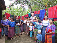 Eine Gruppe von Frauen und Kindern mit einem Mann im Freien.