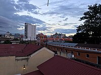 Dächer und Gebäude unter bewölktem Himmel in einer Stadt.