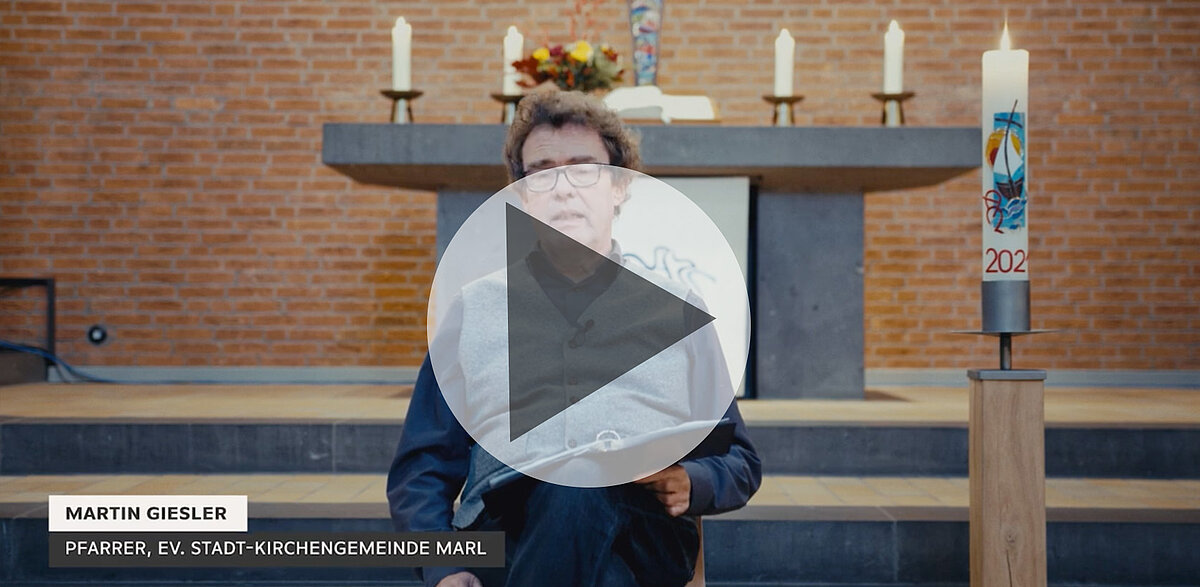 Pfarrer Martin Giesler predigt in Kirche, hält ein Buch.